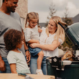Family around Rotisserie on open grill