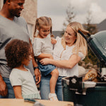 Family around Rotisserie on open grill